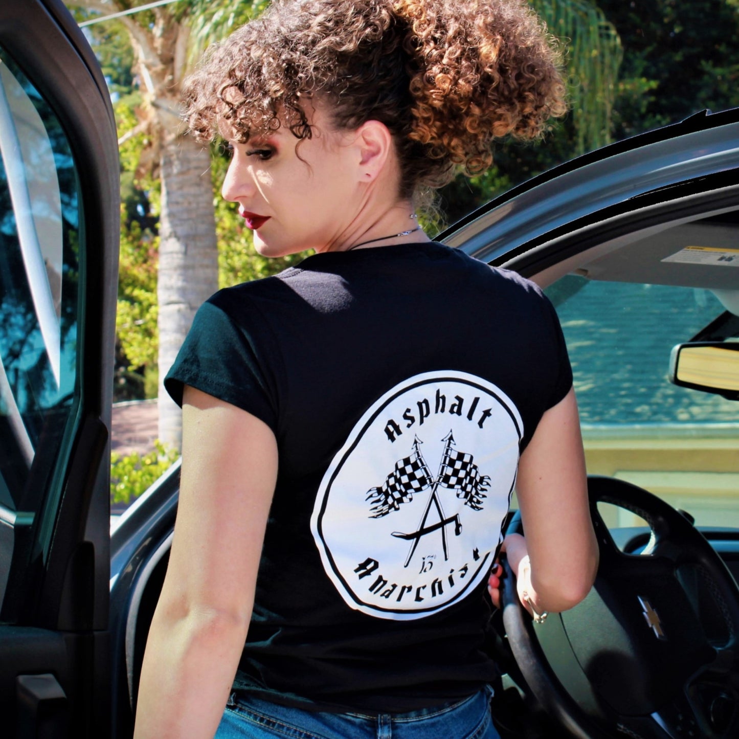 A cute young Rockabilly woman gets into her truck. She is wearing the Finish Line Women's T-Shirt from Asphalt Anarchist Clothing Co. KUSTOM KULTURE APPAREL & PRODUCTS